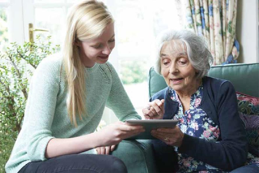 A Young Person Sharing a Handheld Tablet with an Older Person